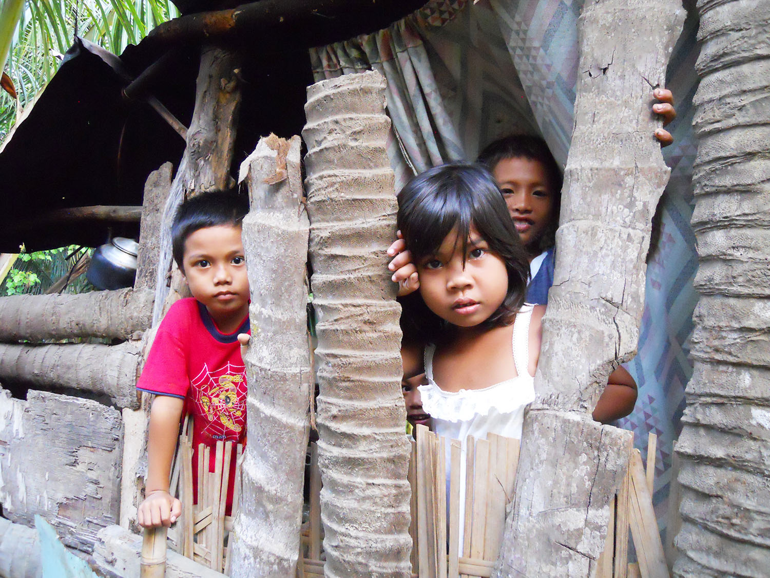 Children, who were in ABC school in Davao during its years of operation, peeping through the cracks of their house