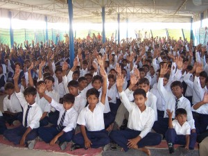 Students Sitting on Floor for Assembly Before Chairs Were Provided